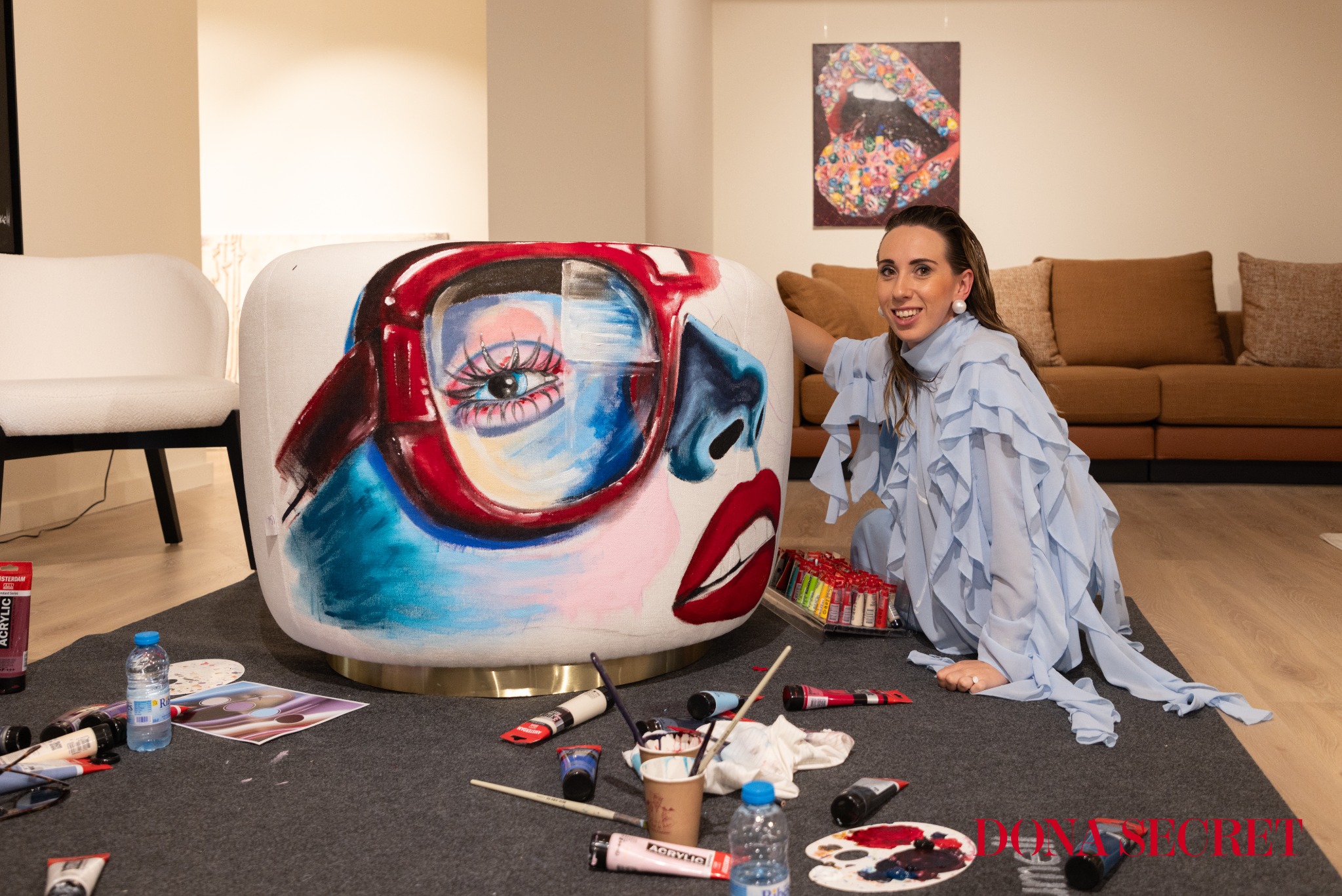 Ona Saumell junto al sofá intervenido con un retrato a color